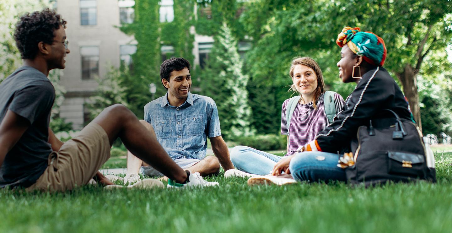 四名学生坐在草坪上谈谈