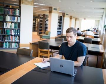 研究计算机的学生克里斯哈里斯在图书馆里。